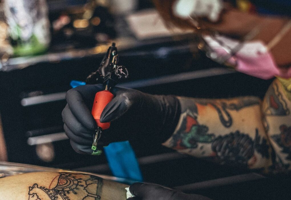 person in black leather gloves holding blue and black plastic toy